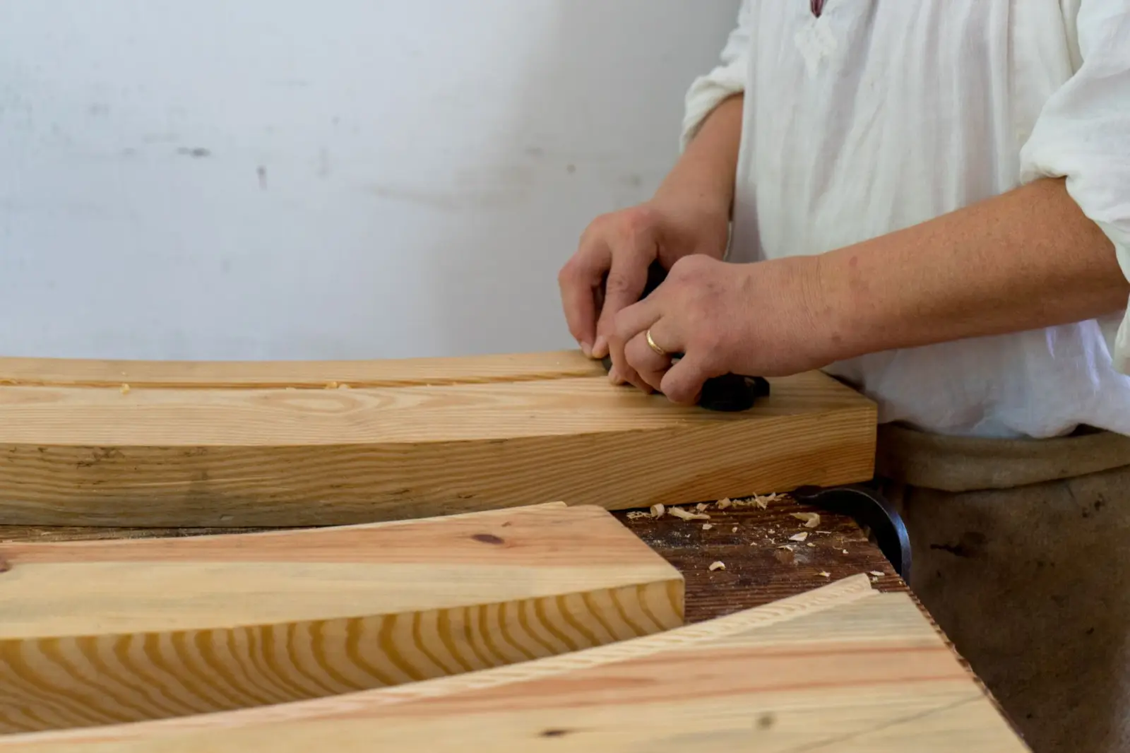 Meșter care prelucrează lemn de stejar în atelier